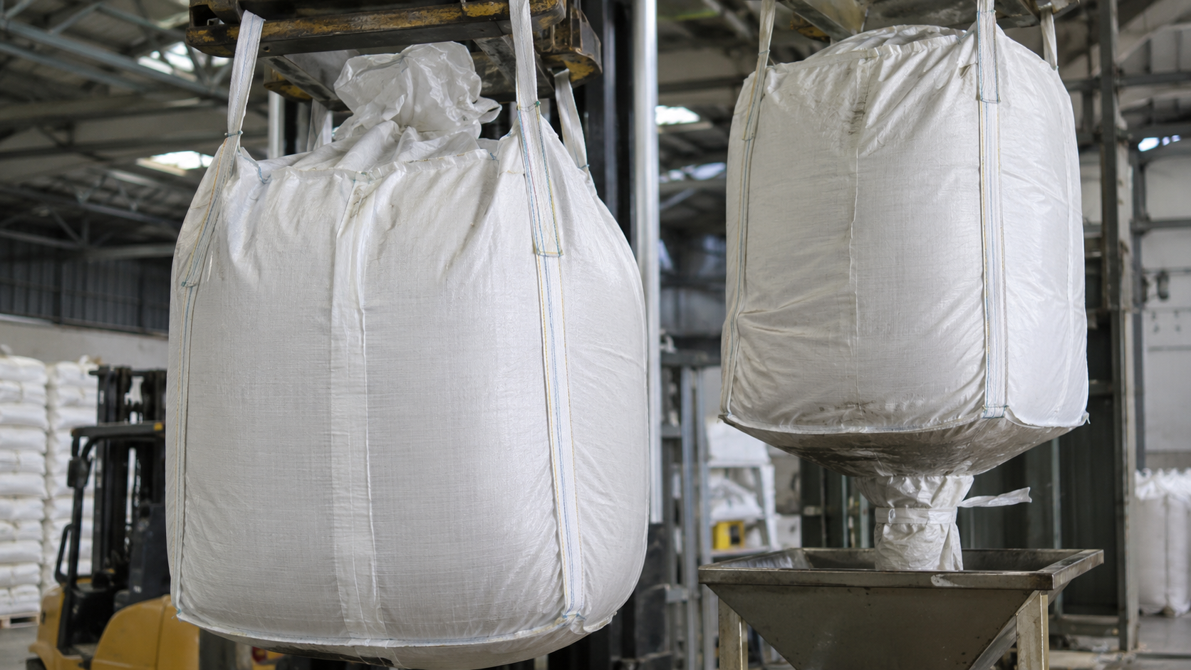 FIBC jumbo bags showing filling and discharge configurations in an industrial warehouse